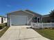 Charming home featuring a well-maintained lawn and a classic white picket fence at 2449 Kingstree Pl, The Villages, FL 32162