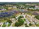 Aerial view of a tranquil community with houses near a scenic lake surrounded by lush greenery and trees at 24802 Pine Hl, Leesburg, FL 34748