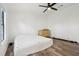 Minimalist bedroom with a ceiling fan, wood-look flooring, and neutral color scheme at 24802 Pine Hl, Leesburg, FL 34748
