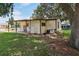 Charming single-story home featuring a covered patio with outdoor laundry hookups and a lush green lawn at 24802 Pine Hl, Leesburg, FL 34748
