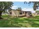 Exterior view of the home with a covered patio and a well-maintained lawn at 24802 Pine Hl, Leesburg, FL 34748
