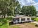 Inviting single-story home with a screened-in porch, covered patio, and well-manicured lawn surrounded by mature trees at 24802 Pine Hl, Leesburg, FL 34748