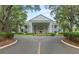 Stately building exterior featuring a grand entrance with large columns, manicured landscaping, and a circular driveway at 24802 Pine Hl, Leesburg, FL 34748