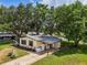Beautiful single-story home featuring a covered patio, screened porch, and long drive surrounded by mature trees and green lawn at 24802 Pine Hl, Leesburg, FL 34748