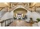 Elegant foyer boasting a grand staircase with wood railings, paneled walls, and a view into a large event space at 24802 Pine Hl, Leesburg, FL 34748
