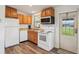Practical kitchen with wooden cabinets, white appliances, and wood-look flooring at 24802 Pine Hl, Leesburg, FL 34748