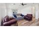 Bright and airy living room featuring wood-look flooring, modern furnishings, and a ceiling fan, creating a relaxing space at 24802 Pine Hl, Leesburg, FL 34748