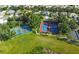 Aerial view showcasing well-maintained tennis and pickleball courts surrounded by lush greenery and neighborhood homes at 24802 Pine Hl, Leesburg, FL 34748