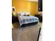 Bedroom with yellow accent wall, carpet, and furniture at 2504 Cavender Creek Rd, Minneola, FL 34715