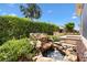 Relaxing back yard includes a rock waterfall feature and beautifully landscaped lawn at 2669 Halsey Ter, The Villages, FL 32162