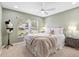 Well-lit bedroom with neutral decor, carpet, and a large window overlooking the neighborhood at 2669 Halsey Ter, The Villages, FL 32162