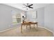 Bedroom features a ceiling fan, a large window, and neutral-toned walls, creating a bright and inviting space at 2669 Halsey Ter, The Villages, FL 32162