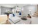 Bright living room features a modern sectional sofa, ceiling fan and opens to the kitchen at 2669 Halsey Ter, The Villages, FL 32162