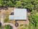 Aerial view of the metal-roofed building, surrounded by lush trees and showcasing the outdoor area at 300 Carol Ann Dr, Edgewater, FL 32132