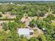 Expansive aerial view showcasing the property's wooded acreage, access roads, and outbuildings at 300 Carol Ann Dr, Edgewater, FL 32132