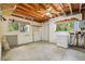 Unfinished basement with exposed ceiling beams, a utility sink, washer, and dryer hookups, ready for customization at 300 Carol Ann Dr, Edgewater, FL 32132