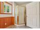 Bathroom featuring a corner shower stall, paneled walls, and tile floors at 300 Carol Ann Dr, Edgewater, FL 32132