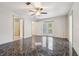 Bedroom boasts dark marble floors, ceiling fan, ensuite bath and private outdoor access at 300 Carol Ann Dr, Edgewater, FL 32132