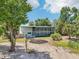 Exterior of a home with screened porch and gravel driveway at 300 Carol Ann Dr, Edgewater, FL 32132