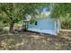 Light blue home with a wooden deck surrounded by mature trees and greenery at 300 Carol Ann Dr, Edgewater, FL 32132