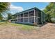 Exterior of home with screened-in porch and adjacent parking area at 300 Carol Ann Dr, Edgewater, FL 32132