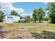 Large lot with metal home and covered parking area, surrounded by green trees and grass at 300 Carol Ann Dr, Edgewater, FL 32132