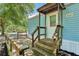 Quaint, covered front porch with wooden railings and steps leading to the light blue home at 300 Carol Ann Dr, Edgewater, FL 32132