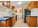 A view of the kitchen with wood cabinets and stainless steel appliances with adjoining laundry area at 300 Carol Ann Dr, Edgewater, FL 32132
