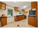 A view of the kitchen showcasing wood cabinets, tile floors and appliances at 300 Carol Ann Dr, Edgewater, FL 32132