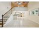 Sun-filled living room boasts tile flooring, high ceilings, staircase and view of the kitchen at 300 Carol Ann Dr, Edgewater, FL 32132