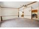 Large living room offering neutral carpeting, a ceiling fan, and an open view to the kitchen at 300 Carol Ann Dr, Edgewater, FL 32132