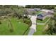 Aerial view of the gated property, mature trees, and a long driveway leading to a charming home with spacious grounds at 3055 Wolf Branch Rd, Mount Dora, FL 32757