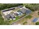 Aerial view of a vast property featuring a main house, a screened pool, outbuildings, and solar panels at 3055 Wolf Branch Rd, Mount Dora, FL 32757
