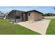 Backyard view of house with screened lanai and concrete patio area at 3055 Wolf Branch Rd, Mount Dora, FL 32757