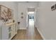 Hallway showcasing wood-look tile flooring, a decorative console table, art, and a glimpse of the pool view beyond at 3055 Wolf Branch Rd, Mount Dora, FL 32757