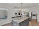 Kitchen island with marble countertops, seating, and a chandelier at 3055 Wolf Branch Rd, Mount Dora, FL 32757