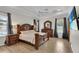Spacious main bedroom with wood-look tile floors, tray ceiling, and dark wood furniture at 3055 Wolf Branch Rd, Mount Dora, FL 32757