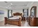 The main bedroom features a luxurious wood bed, tray ceilings, and hardwood floors at 3055 Wolf Branch Rd, Mount Dora, FL 32757