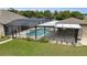 Screened-in pool area featuring a refreshing pool, hot tub, and an outdoor kitchen with a bar for entertaining at 3055 Wolf Branch Rd, Mount Dora, FL 32757