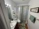 Cozy bathroom featuring a tub with shower, decorative shower curtain, and patterned bath mats at 5041 Cr 577, Center Hill, FL 33514