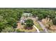 An aerial view showcasing the property with a pool, surrounded by lush landscaping and mature trees at 6905 Clayton St, Mount Dora, FL 32757