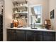 Charming bar area featuring stylish shelving, ample counter space, and a sink, ideal for entertaining guests at 6905 Clayton St, Mount Dora, FL 32757