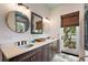 Charming bathroom featuring double sinks, and a window offering a lovely view of greenery at 6905 Clayton St, Mount Dora, FL 32757