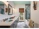 Charming bathroom featuring double sinks, and a window offering a lovely view of greenery at 6905 Clayton St, Mount Dora, FL 32757