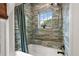 This cozy bathroom features tile walls, a bathtub, and a window with a view at 6905 Clayton St, Mount Dora, FL 32757