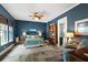 Elegant bedroom with blue walls, a comfortable bed, and thoughtful decor, creating a serene and inviting atmosphere at 6905 Clayton St, Mount Dora, FL 32757