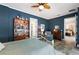 This spacious bedroom features blue walls, a unique ceiling fan, and elegant slate floors at 6905 Clayton St, Mount Dora, FL 32757