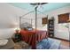 An elegant bedroom features a four-poster bed, hardwood floors, and stylish decor, creating a relaxing retreat at 6905 Clayton St, Mount Dora, FL 32757