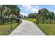 Long driveway leading to a grand home, framed by manicured landscaping and a gated entrance at 6905 Clayton St, Mount Dora, FL 32757