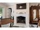Close-up view of a stylish fireplace with a mantel, decorative candles, and a rustic wood accent, adding warmth to the space at 6905 Clayton St, Mount Dora, FL 32757